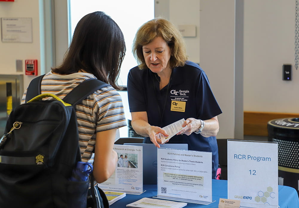 GPE staff member helping student at GradExpo New Student Resource Fair