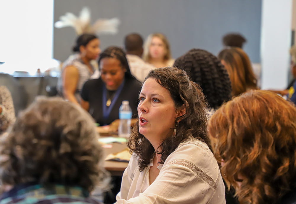 Participants conversing in small groups at Graduate Education Summit